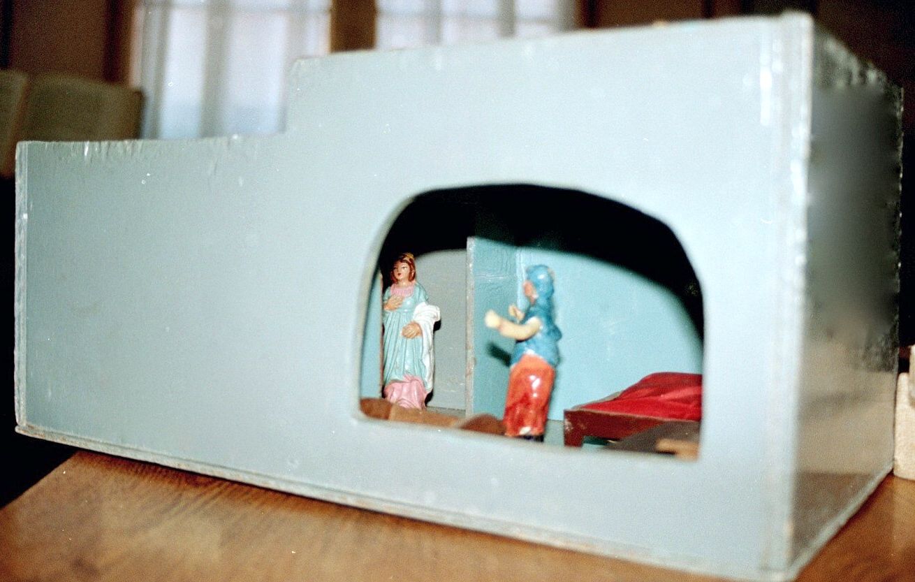a close up of a toy house with a doll in it.