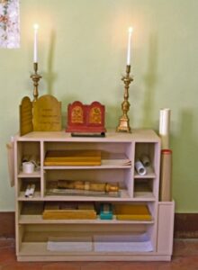 a shelf with books and candles on top of it.