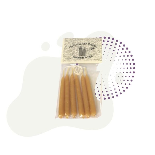 A package of four Beeswax candles sitting on top of a table.