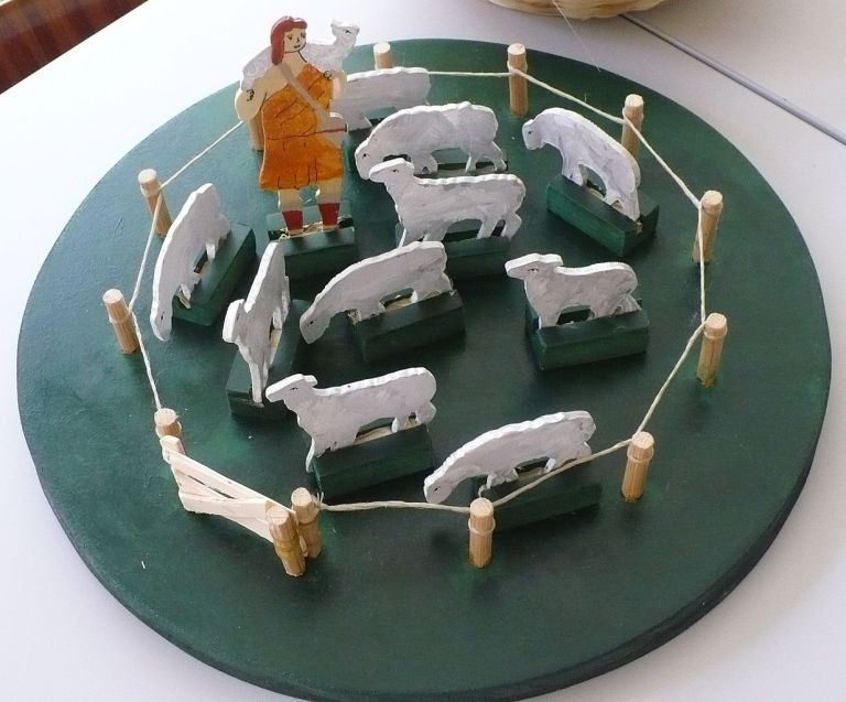 a green plate topped with white sheep on top of a table.