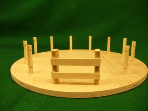 a wooden model of a boxing ring on a green background.