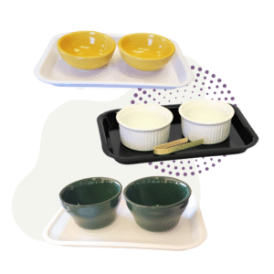 The Paschal Candle Holder Set includes three tray sets: yellow bowls on a white tray, white ramekins with a gold spoon on a black tray, and green bowls on a white tray.