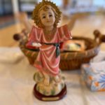 a figurine of a little girl sitting on a table.