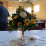 a bouquet of yellow and white flowers on a table.