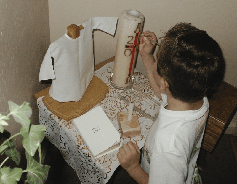 a little boy works with the Paschal Candle