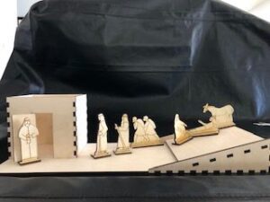 A wooden nativity scene with figures on it.